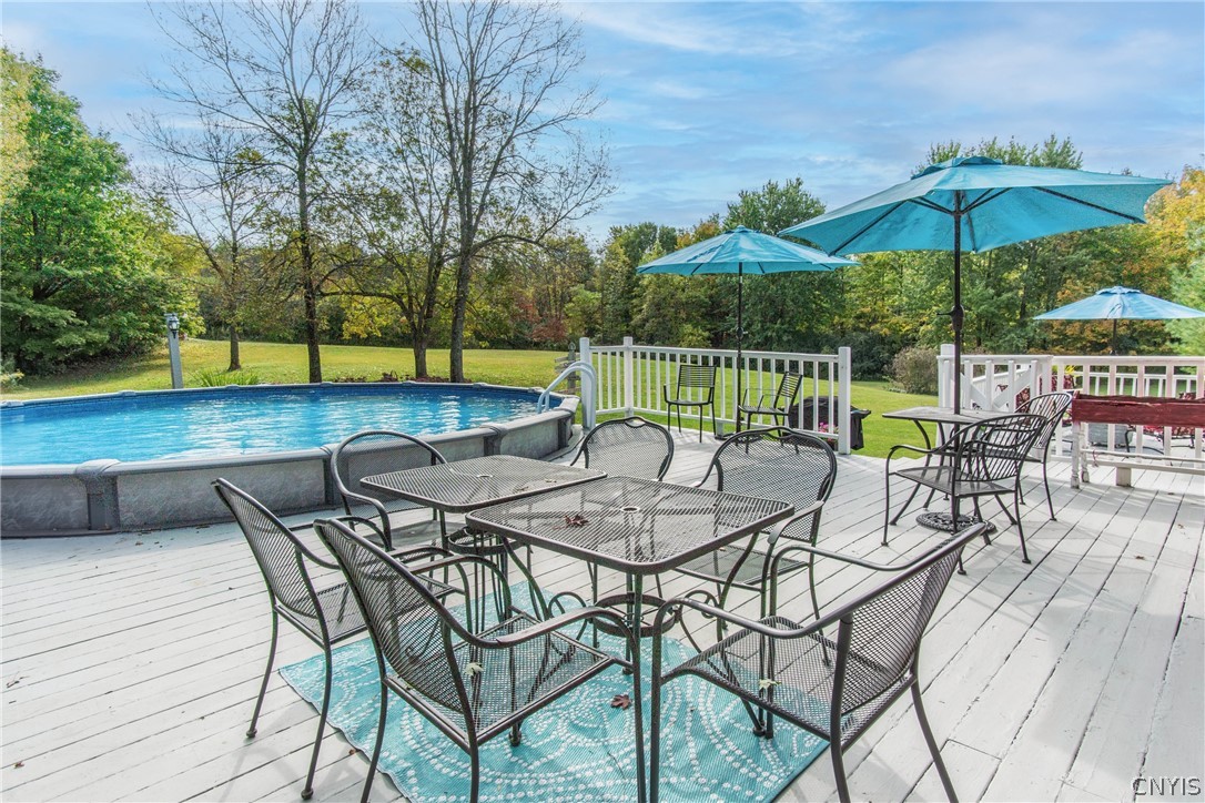 15384 Fuller Road Adams, NY 13606 - Photo 11 of 50 A spacious wooden deck overlooks the pool and sprawling lawn surrounded by mature trees.