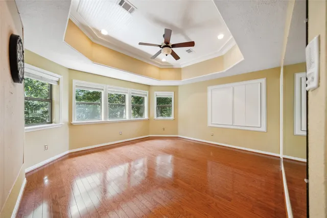 a view of an empty room with a window and wooden floor