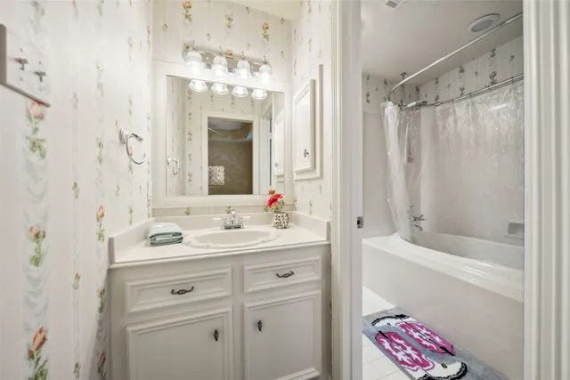 a bathroom with a double vanity sink mirror and bathtub