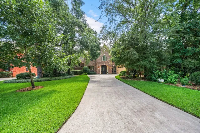 a front view of a house with a yard and a tree