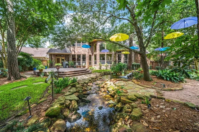 a front view of a house with garden and trees