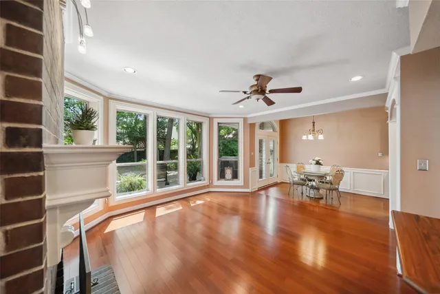 a view of an empty room with wooden floor and windows