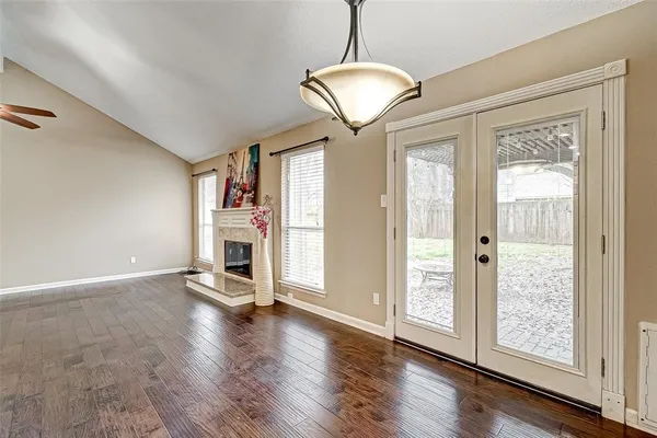 a view of a livingroom with wooden floor a ceiling fan and windows