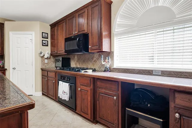 a kitchen with stainless steel appliances granite countertop a sink and a stove