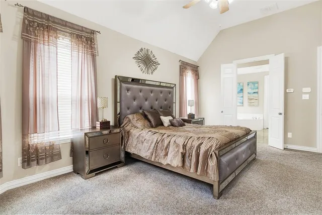 a bed sitting in a spacious bedroom next to a window