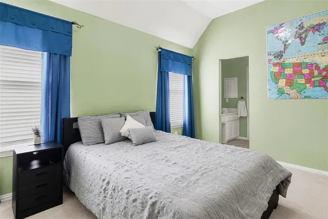 a large bed in a bedroom next to a window