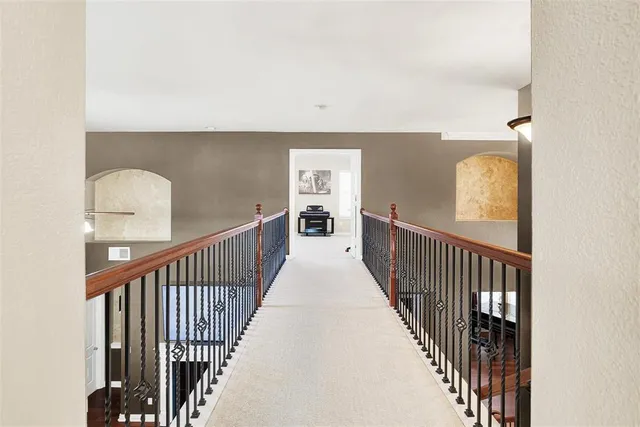 a view of a hallway with wooden floor and stairs