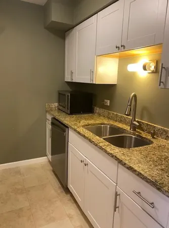 a kitchen with granite countertop a sink and a stove