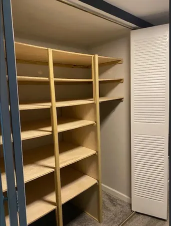 a view of walk in closet with empty racks