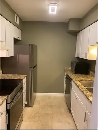 a kitchen with stainless steel appliances granite countertop a refrigerator and a stove