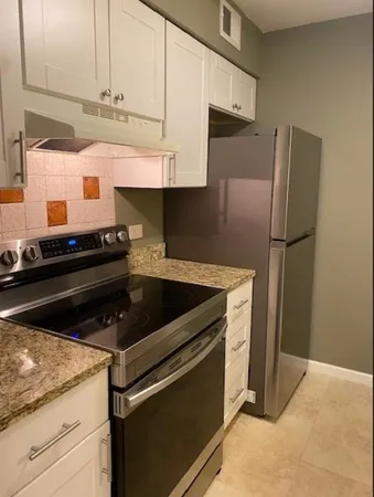 a kitchen with stainless steel appliances granite countertop a refrigerator and a stove
