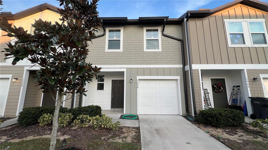 1064 Appleton Street Davenport, FL 33837 - Photo 1 of 28 a front view of a house with garden
