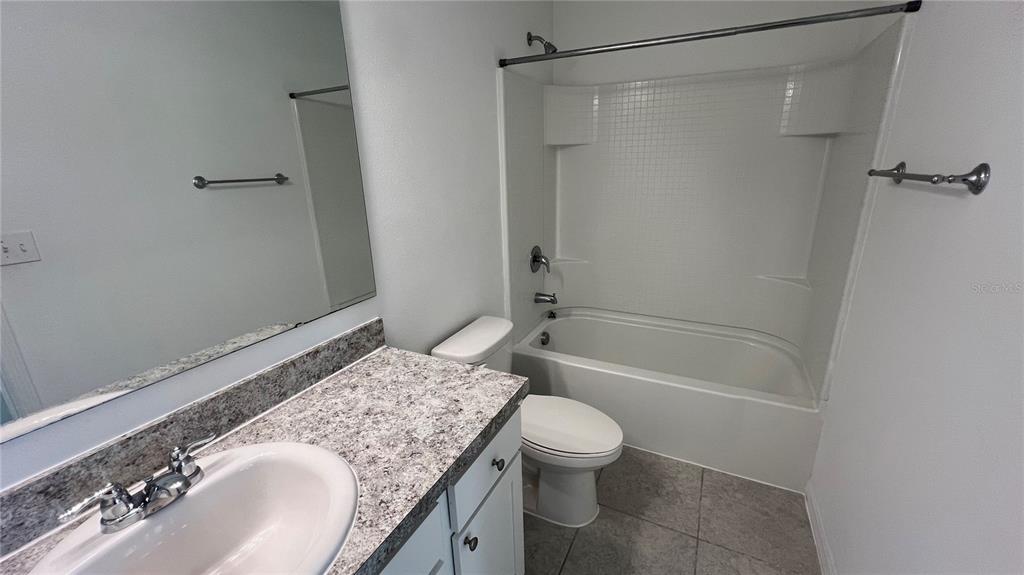 1064 Appleton Street Davenport, FL 33837 - Photo 16 of 28 a bathroom with a granite countertop sink toilet and shower