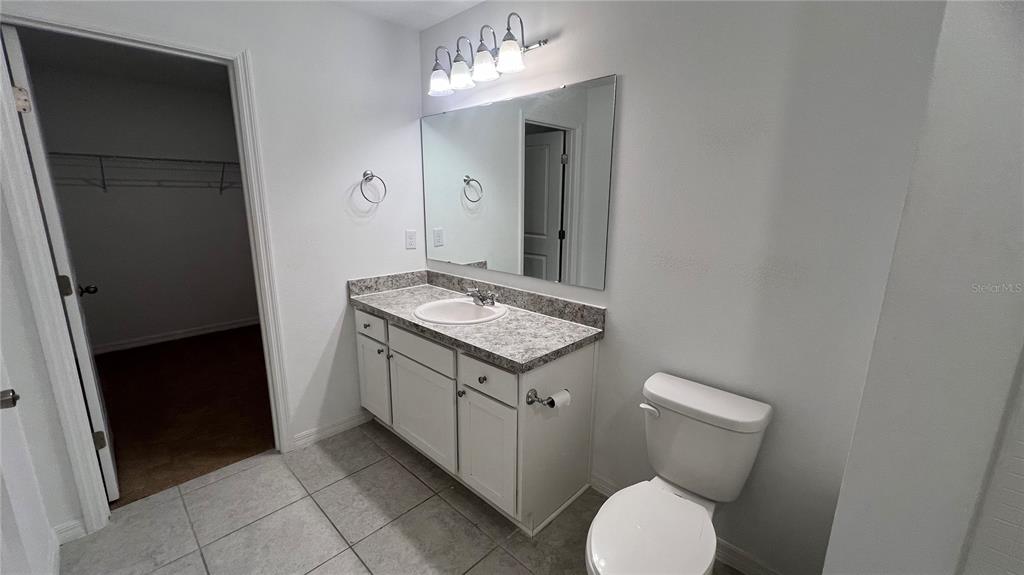 1064 Appleton Street Davenport, FL 33837 - Photo 24 of 28 a bathroom with a granite countertop toilet and a sink