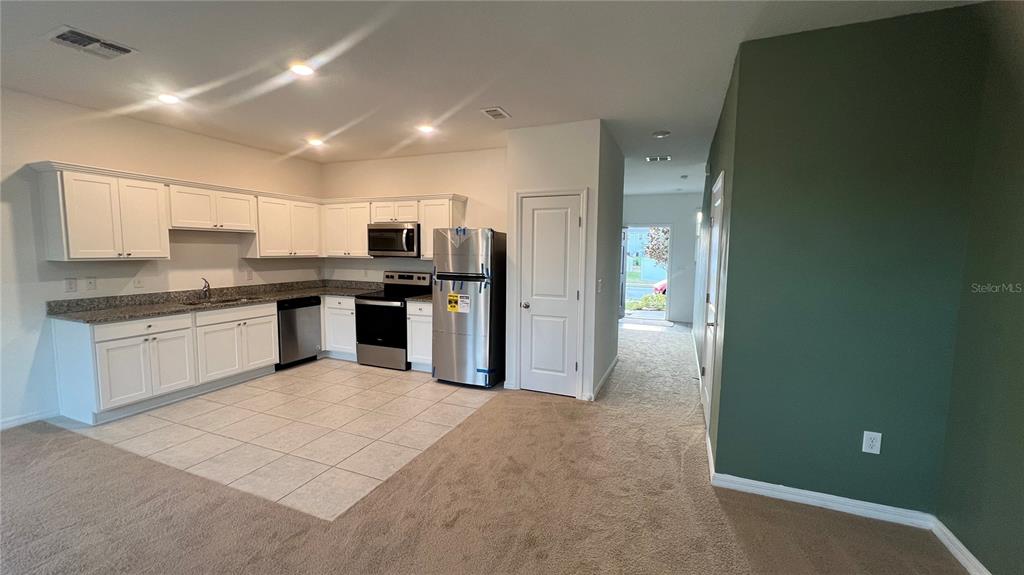 1064 Appleton Street Davenport, FL 33837 - Photo 7 of 28 a large kitchen with cabinets and stainless steel appliances