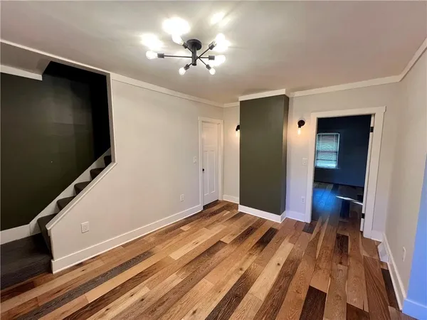 a view of a livingroom with wooden floor and a flat screen tv