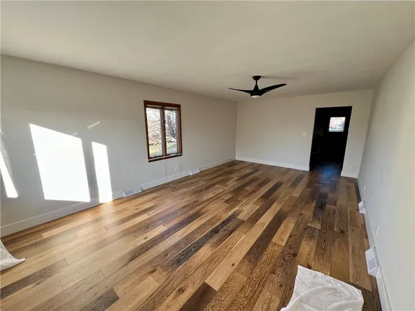 wooden floor in an empty room with a window
