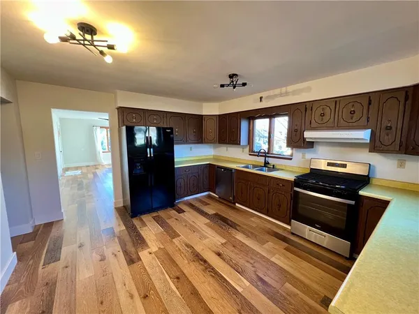 a kitchen with stainless steel appliances granite countertop a refrigerator and a stove top oven