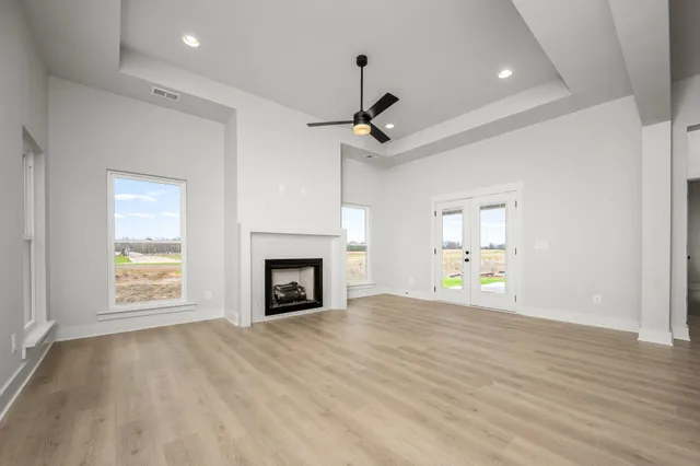 a view of empty room with wooden floor fireplace and windows