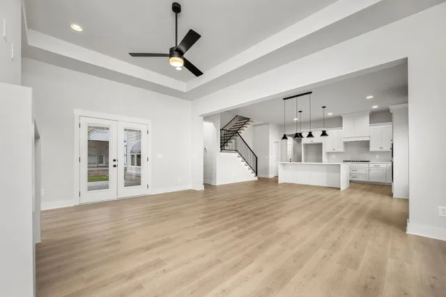 a view of empty room with wooden floor and ceiling fan