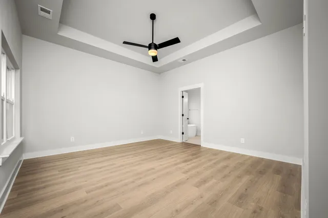 a view of a room with wooden floor and ceiling fan
