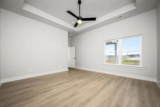 a view of a livingroom with a ceiling fan window and wooden floor