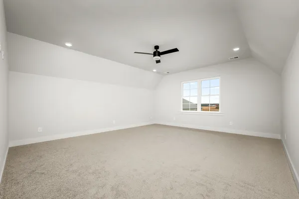 an empty room with a window and a ceiling fan