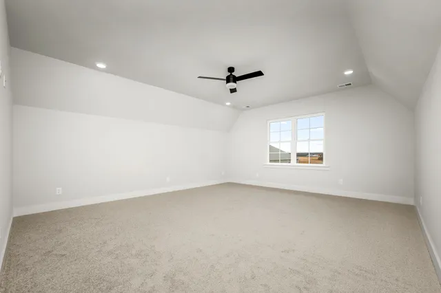 an empty room with a window and a ceiling fan