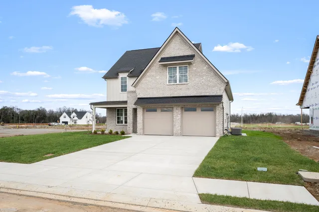 a front view of a house with a garden and yard