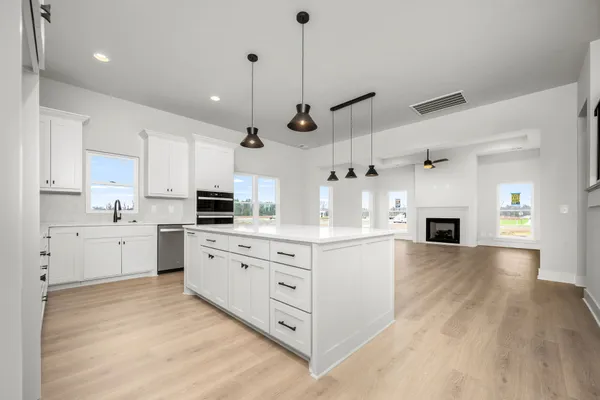 a kitchen with stainless steel appliances white cabinets and wooden floors