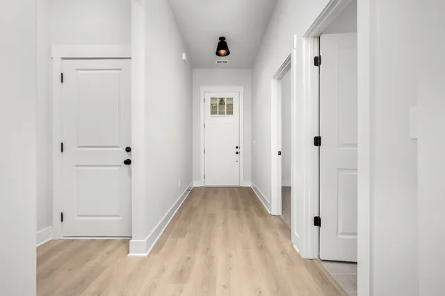 a view of a hallway with wooden floor