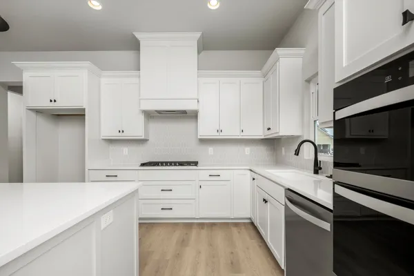 a kitchen with white cabinets stainless steel appliances and sink