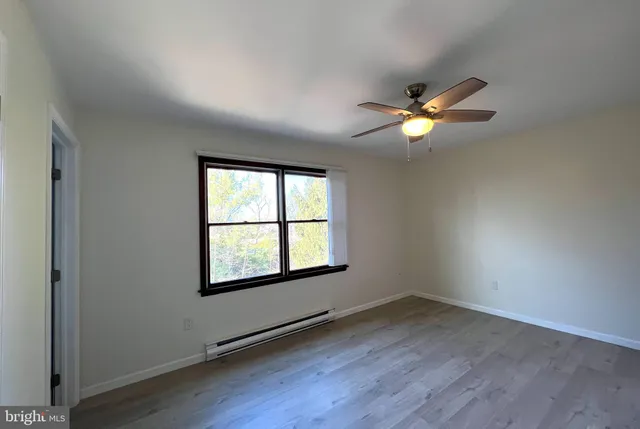 an empty room with a window and a fan