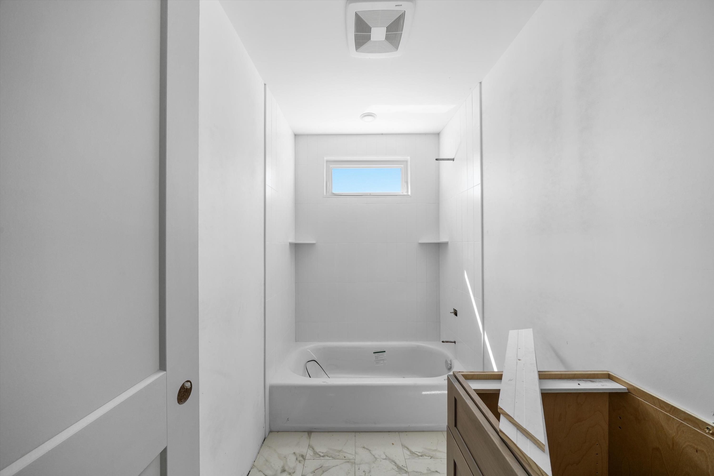 242 57th Street, Unit WEST Sea Isle City, NJ 08243 - Photo 9 of 20 a bathroom with a tub a sink and a vanity