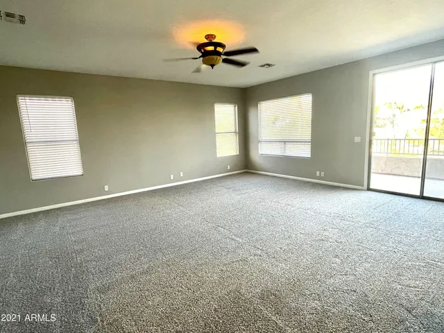 an empty room with a window and a ceiling fan