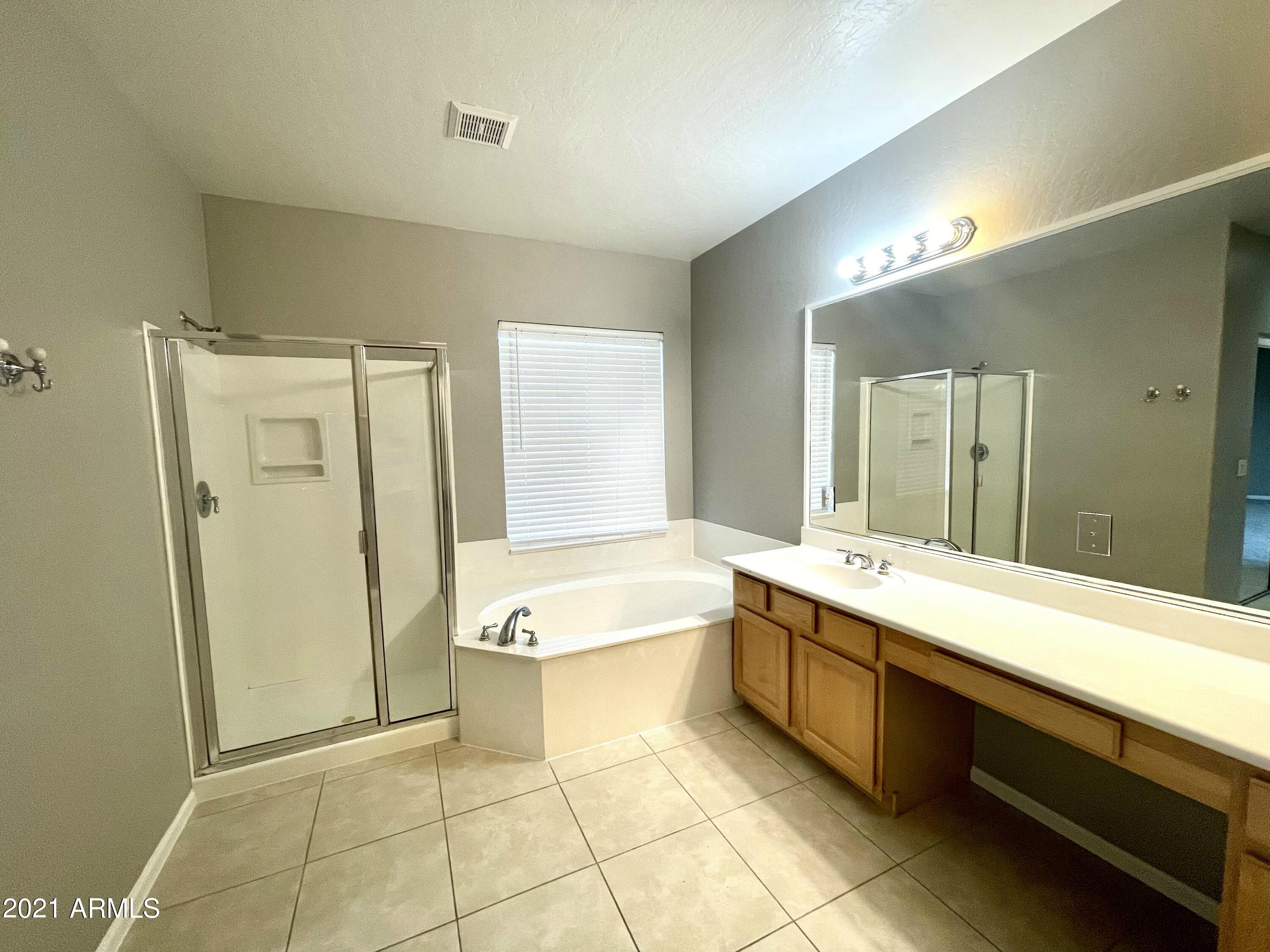 1608 West Amberwood Drive Phoenix, AZ 85045 - Photo 8 of 13 a bathroom with a tub sink and mirror