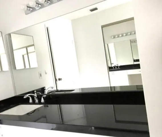 a bathroom with a sink a mirror and a window