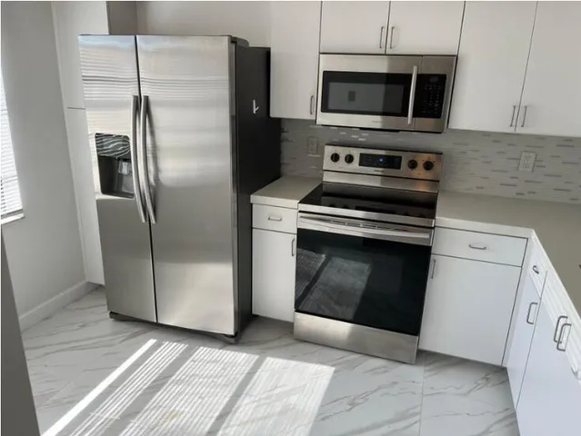 a kitchen with a stove top oven and refrigerator