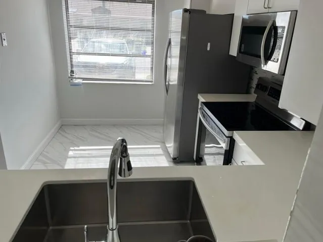 a kitchen with a sink and a refrigerator