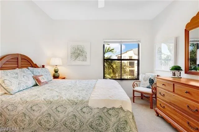 a bedroom with a bed and a dresser next to a window