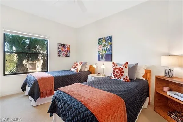 a bedroom with two beds and a large window