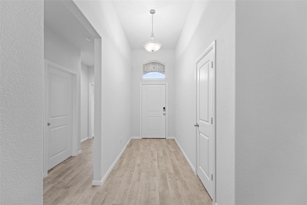 9020 Ridgeriver Way Fort Worth, TX 76131 - Photo 5 of 26 a view of a hallway with wooden floor and a chandelier