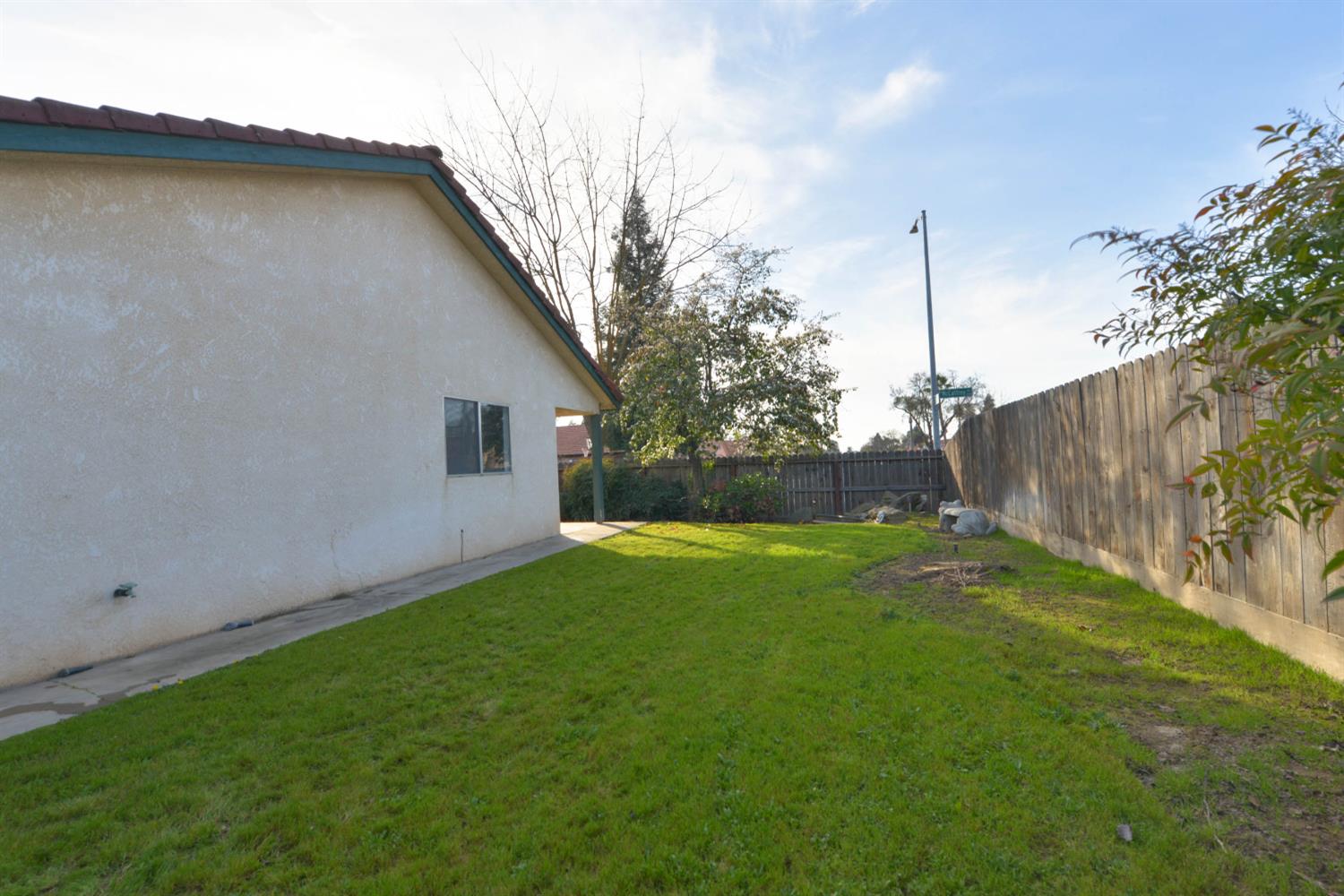 5572 West Sample Avenue Fresno, CA 93722 - Photo 15 of 42 a view of a backyard with potted plants