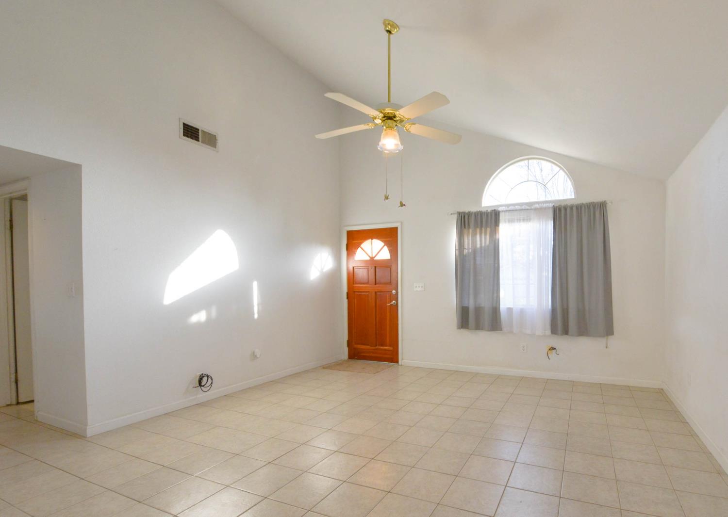5572 West Sample Avenue Fresno, CA 93722 - Photo 23 of 42 a view of a livingroom with a chandelier fan and windows