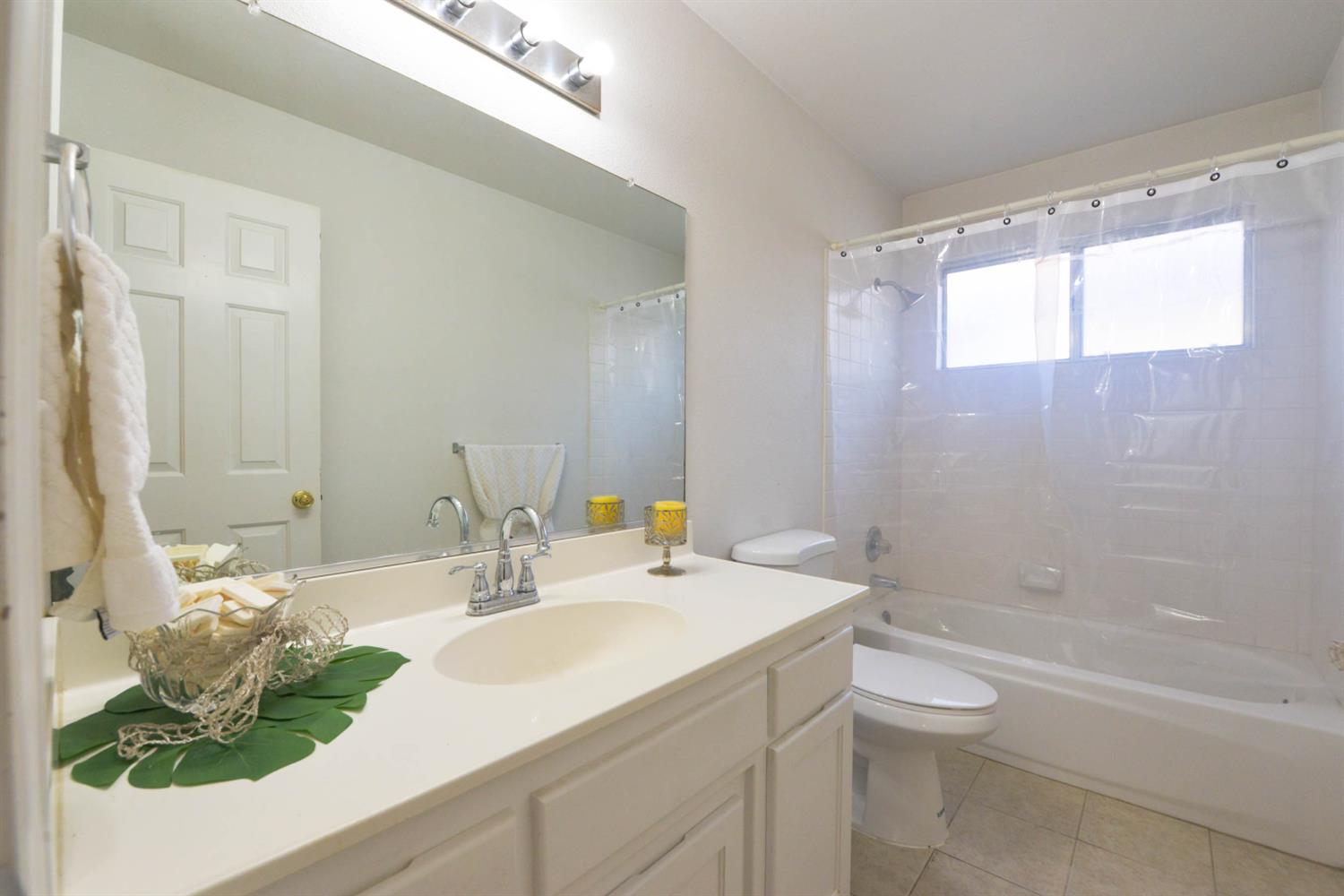 5572 West Sample Avenue Fresno, CA 93722 - Photo 40 of 42 a bathroom with a granite countertop sink a toilet and bathtub