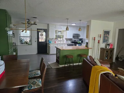 a view of a dining room kitchen and livingroom with furniture wooden floor a chandelier