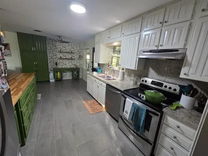a kitchen with stainless steel appliances granite countertop a stove a sink and a refrigerator