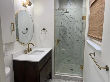 a bathroom with a sink a mirror and shower