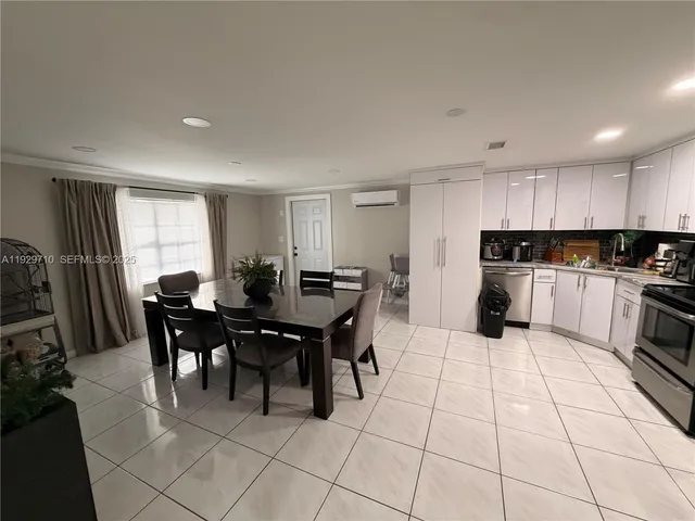 a kitchen with stainless steel appliances granite countertop a stove a sink a dining table and chairs