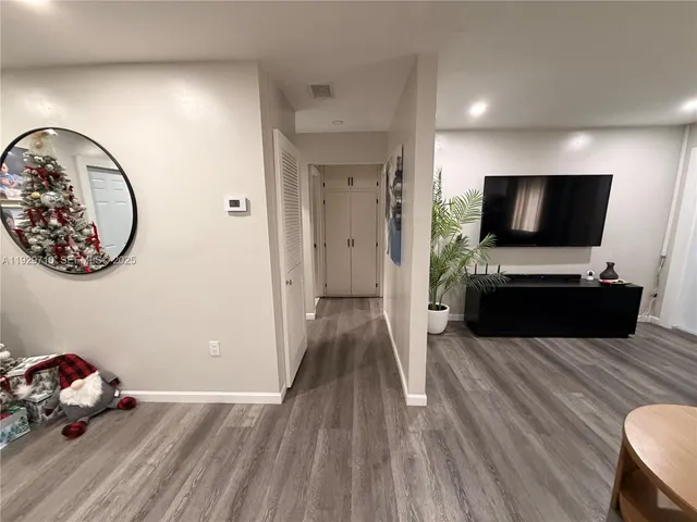 an empty room with wooden floor and mirror